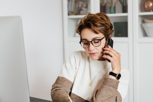 person-talking-on-the-phone-while-writing-something-down