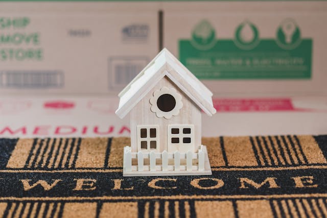 wooden-toy-house-on-a-welcome-mat