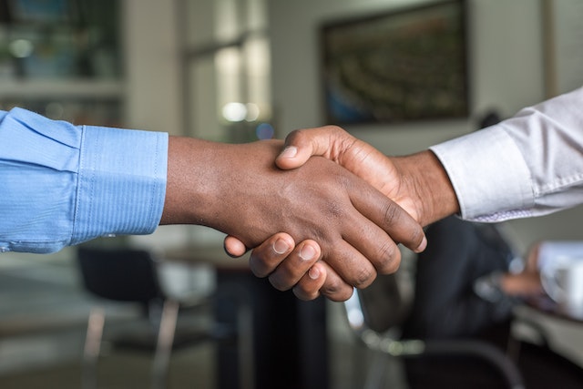 two-people-wearing-long-sleeves-shirts-shaking-hands